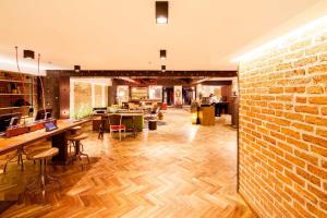 a lobby with a brick wall and tables and chairs at Hotel Presidente in San José
