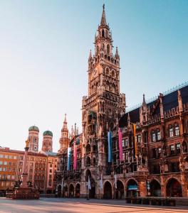 um grande edifício com uma torre de relógio em frente em Exclusive Maxvorstadt Studio em Munique