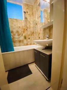 uma casa de banho com um lavatório e uma banheira em Exclusive Maxvorstadt Studio em Munique