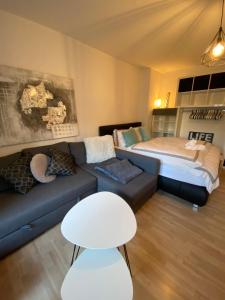 uma sala de estar com um sofá e uma cama em Exclusive Maxvorstadt Studio em Munique