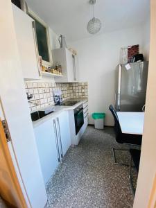 uma pequena cozinha com um lavatório e um frigorífico em Exclusive Maxvorstadt Studio em Munique