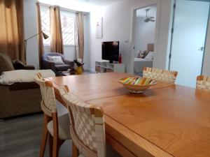 salon z drewnianym stołem jadalnym i krzesłami w obiekcie Apartamento céntrico recién reformado w Murcji