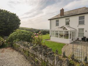 an image of a white house with a conservatory at Home Farm in Boscastle