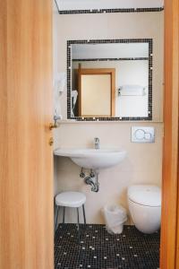 a bathroom with a sink and a toilet and a mirror at Hotel Corallo in La Spezia