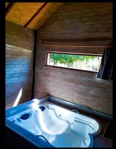 una vasca da bagno in una stanza con finestra di Chalé na Montanha a Santo Antônio do Pinhal