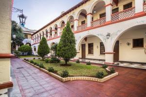 a courtyard of a building with trees and bushes at Hotel Urdiñola Saltillo in Saltillo