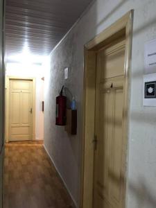 a hallway with a door and a fire extinguisher on a wall at Hotel Popular Vila Mariana in Sao Paulo