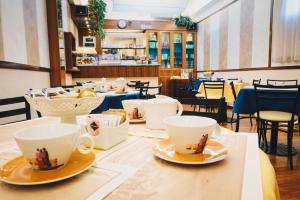 a table with cups and saucers on it in a restaurant at Hotel Corallo in La Spezia
