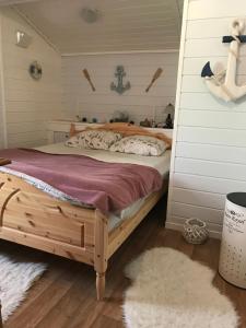 a bedroom with a wooden bed in a room at Ferienhaus „Draumen“ in Norwegen in Bømlo