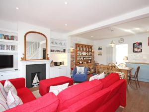 a living room with a red couch and a fireplace at Dory Cottage in Salcombe