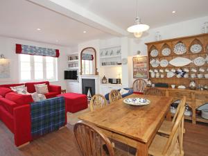 a living room with a table and a red couch at Dory Cottage in Salcombe
