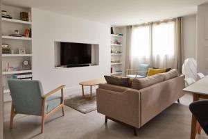 sala de estar con sofá y TV en Urban Ezcaray, en Ezcaray