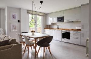 a kitchen with white cabinets and a table and chairs at Urban Ezcaray in Ezcaray