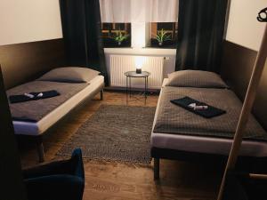two beds in a room with a table and a window at Caffe Boulevard Penzion in Waldsassen