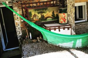 a green hammock in front of a house with a painting at Pensión Santa Rosa in Samos