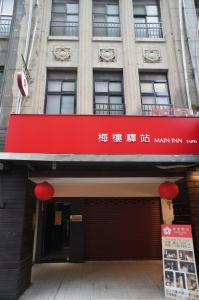 un edificio con una señal roja en la parte delantera. en Main Inn Taipei, en Taipéi