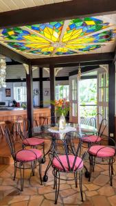 a dining room with a table and chairs with a stained glass ceiling at MOOREA - Villa Tereva Nui in Haapiti