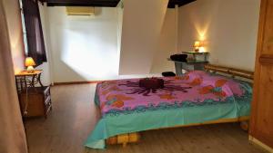 a bedroom with a bed with a colorful blanket at MOOREA - Villa Tereva Nui in Haapiti