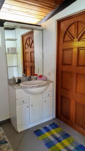 baño con lavabo, espejo y puerta en MOOREA - Villa Tereva Nui en Haapiti