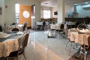 a restaurant with tables and chairs in a room at Holambra Garden Hotel in Holambra
