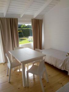 Una mesa blanca y sillas en una habitación con cama en BQS House en Miramar