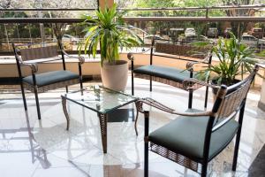 un grupo de sillas y una mesa de cristal en un patio en Holambra Garden Hotel, en Holambra