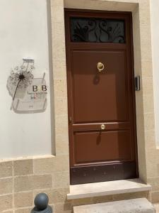 una puerta marrón en el lateral de un edificio en Sine Tempore B&B, en Manduria
