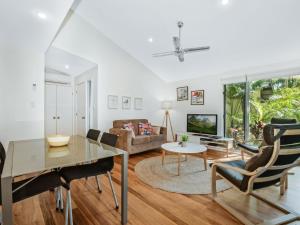 a living room with a table and chairs and a couch at Mobys Beach house 11 in Boomerang Beach