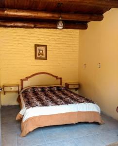 una camera con un grande letto su una parete gialla di Social-Club La Cueva a Minas
