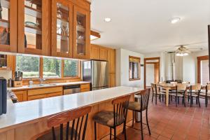 eine Küche mit Holzschränken und einem Tisch mit Stühlen in der Unterkunft Lakeview Home with new hot tub - Sleeps 10 in Sandpoint
