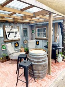 a patio with a table and a grill and a barrel at The Little Red Shed in Russell