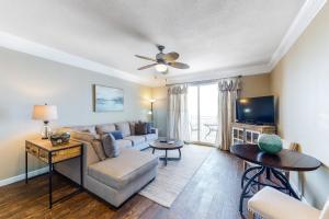 a living room with a couch and a tv at Sterling Reef 404 in Panama City Beach