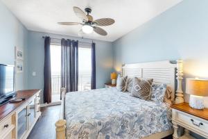 a bedroom with a bed and a ceiling fan at Sterling Reef 404 in Panama City Beach