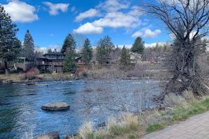a view of a river with houses in the background at Deschutes Riverside Escape in Bend