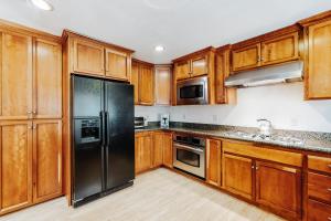 a kitchen with wooden cabinets and a black refrigerator at Makoto in Stateline