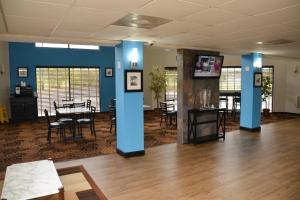 Cette chambre est dotée d'une table, de chaises et de murs bleus. dans l'établissement Baymont by Wyndham Santee, à Santee