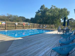 a swimming pool with two chairs and a table on a wooden deck at Tilghman Island Inn in Tilghman Island