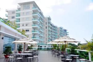 un patio extérieur avec des tables, des chaises et des parasols dans l'établissement Ocean View Studio,Ocean View 3BR-apartment, Sealinks City, Mui Ne, à Phan Thiết