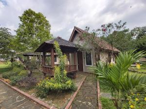 uma pequena casa com um jardim em frente em Degung Hillside em Bogor