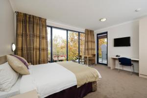 a hotel room with a bed and a large window at Carlton Lygon Lodge - Close to Melbourne Uni in Melbourne