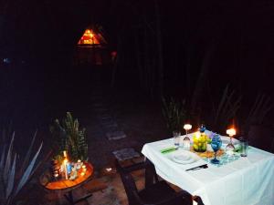 a table with a white table cloth and candles on it at Glamping Los Ángeles in Guasca