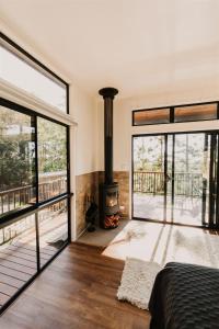 a bedroom with a fireplace and sliding glass doors at Rainforest Gardens - Luxury Hillside Accomodation with Views to Bay & Islands in Mount Cotton