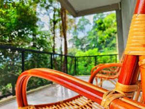 two wooden benches sitting on a porch with a view at Harmony Valley Retreat in Bukit Tinggi