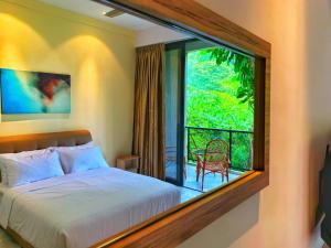 a bedroom with a bed and a large window at Harmony Valley Retreat in Bukit Tinggi