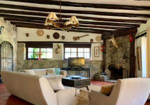 una sala de estar con sofás y una chimenea de piedra. en Casa de Campo Cieneguilla Chontay, en Nieve Nieve