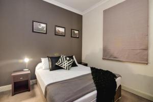 a bedroom with a white bedspread and white pillows at Royal Hotel Gympie in Gympie