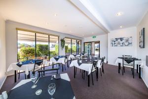 un ristorante con tavoli e sedie in bianco e nero di Ascot Lodge Motor Inn a Kingaroy