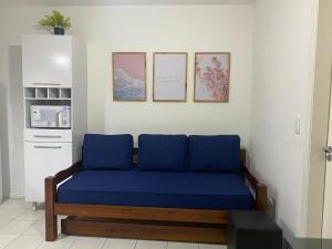 a blue couch in a room with pictures on the wall at Flat juquehy L&H in Juquei