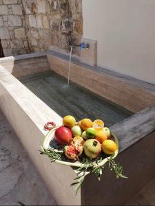 un tazón de fruta sentado en un tazón de agua en House of Eleni, en Káthikas