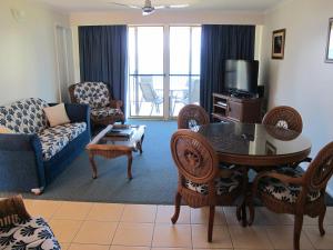 - un salon avec un canapé, une table et des chaises dans l'établissement Rose Bay Resort, à Bowen